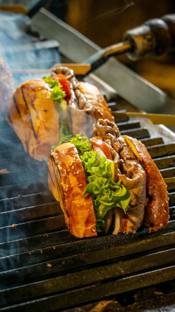 Mouthwatering grilled steak sandwiches with fresh lettuce and tomato on BBQ.