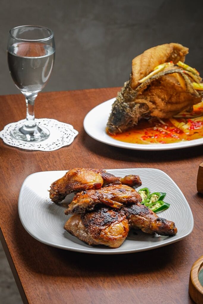 Traditional Indonesian grilled chicken and fish dish served indoors.